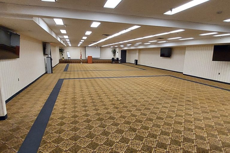 a large room with a projector screen and a podium